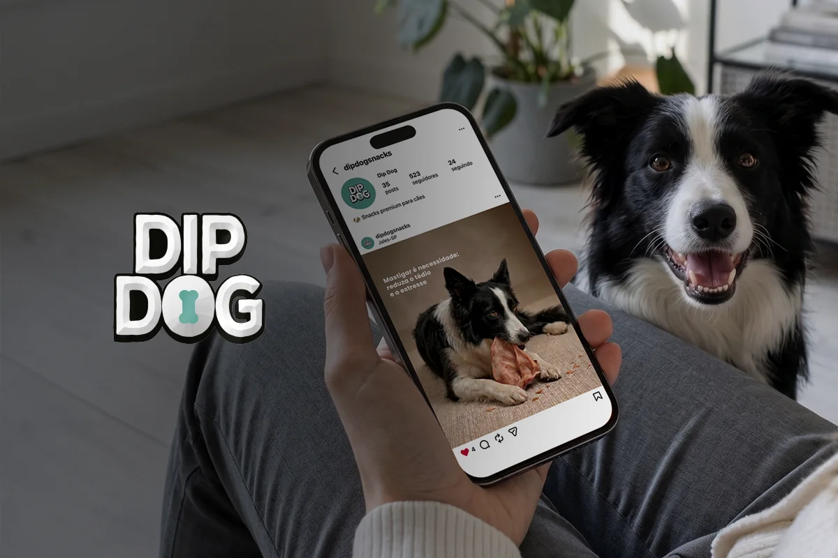 pessoa segurando celular que mostra o perfil do Instagram da DipDog com um Border Collie roendo petisco natural ao fundo